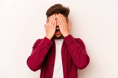 Beyaz arka planda izole edilmiş, yüzünün yarısını palmiye ile örterek eğlenen genç bir İspanyol..