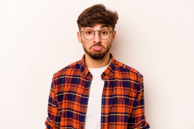 Genç İspanyol adam beyaz arka planda izole edilmiş üzgün, ciddi yüzlü, mutsuz ve hoşnutsuz..