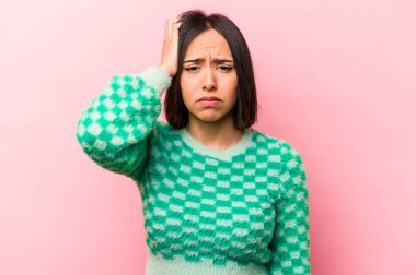 Pembe arka planda izole edilmiş genç İspanyol kadın yorgun ve uykulu ellerini başının üstünde tutuyor..