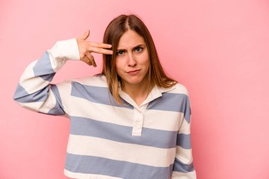 Pembe arka planda izole edilmiş beyaz bir kadın işaret parmağıyla hayal kırıklığı jesti gösteriyor..