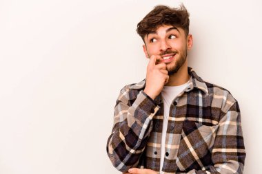 Beyaz arka planda izole edilmiş genç İspanyol bir adam rahatlamış bir şeyin fotokopi odasına baktığını düşünüyor..