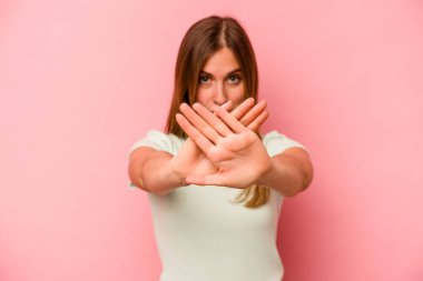 Pembe arka planda izole edilmiş beyaz bir kadın inkar jesti yapıyor.