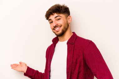 Beyaz arka planda izole edilmiş genç bir İspanyol hoş geldin ifadesi sergiliyor..