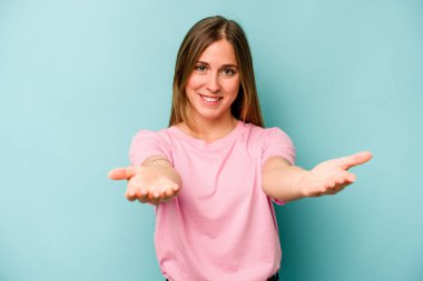 Mavi arka planda izole edilmiş beyaz bir kadın hoş bir ifade sergiliyor..