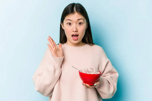 Jonge Aziatische Vrouw Met Een Kom Van Granen Geïsoleerd Blauwe — Stockfoto