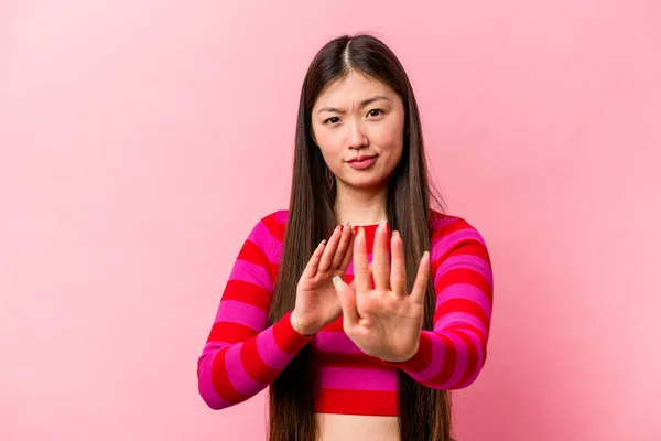 年轻的中国女人 背景是粉红的 手伸出来 露出停止的痕迹 不让你离开 — 图库照片
