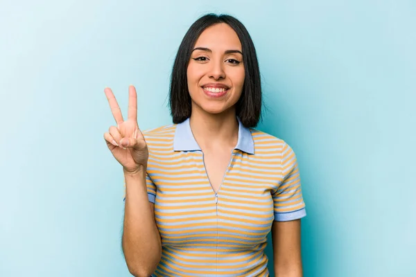 Jonge Spaanse Vrouw Geïsoleerd Blauwe Achtergrond Met Overwinningsteken Brede Glimlach — Stockfoto