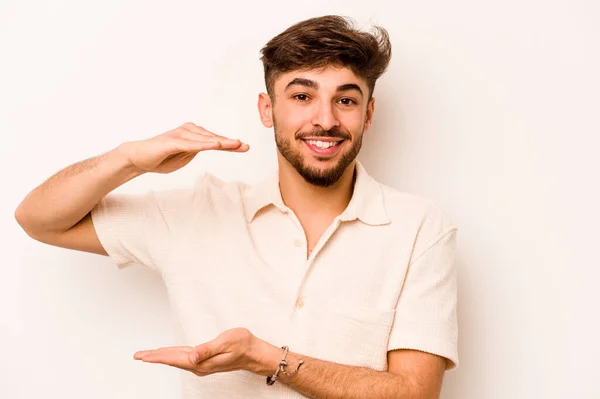 Young Hispanic Man Isolated White Background Holding Something Little Forefingers — стоковое фото