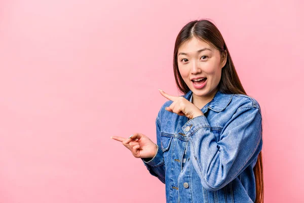 Jovem Chinesa Isolada Fundo Rosa Animado Apontando Com Dedos Indicador — Fotografia de Stock