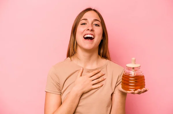 Young Caucasian Woman Holding Honey Isolated Pink Background Laughs Out — Stock Photo, Image