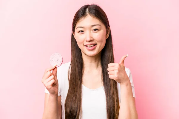 Junge Asiatische Frau Hält Gesichtsschwamm Isoliert Auf Rosa Hintergrund Lächelnd — Stockfoto