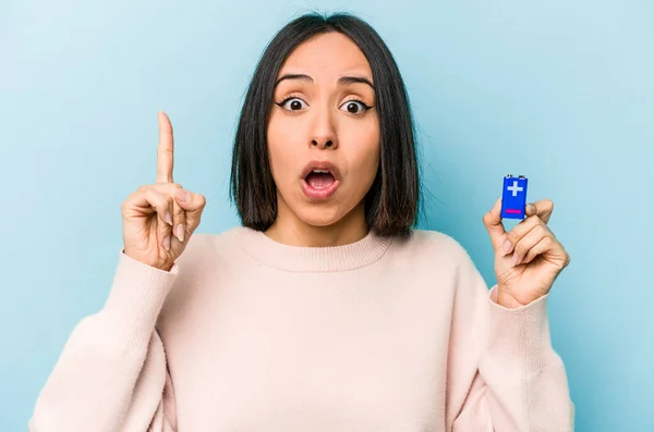 年轻的惊慌失措的女人拿着蓝色背景的电池 有一个想法 有灵感的概念 — 图库照片