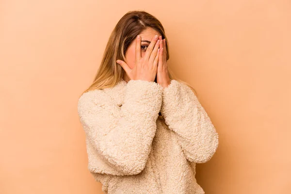 Mujer Joven Caucásica Aislada Sobre Fondo Beige Parpadea Través Los —  Fotos de Stock