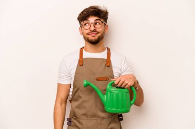 Genç bahçıvan, elinde su dolu bir teneke tutarak beyaz arka planda amaçlarına ve amaçlarına ulaşmayı düşlüyor.