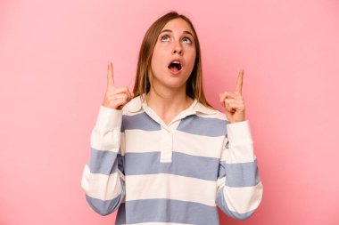 Pembe arka planda izole edilmiş beyaz bir kadın ağzı açık bir şekilde üst tarafı işaret ediyor..