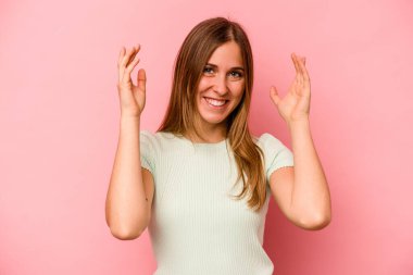 Pembe arka planda izole edilmiş beyaz bir kadın neşeli bir şekilde gülüyor. Mutluluk kavramı.