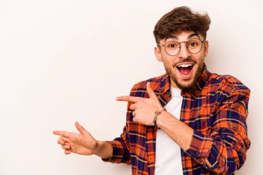 Beyaz arka planda izole edilmiş genç bir İspanyol işaret parmaklarıyla işaret ederek heyecanlanıyor..