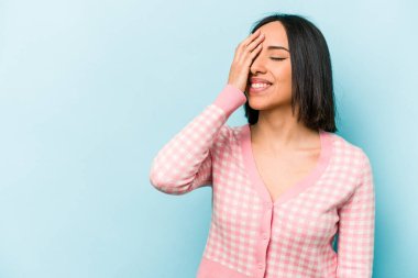 Genç İspanyol kadın mavi arka planda izole edilmiş gülerek, kaygısızca, doğal duygularla..