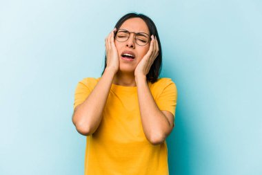 Genç İspanyol kadın mavi arka planda yalnız başına sızlanıyor ve ağlıyordu..