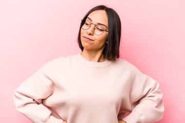 Pembe arka planda izole edilmiş genç İspanyol kadın hedeflerine ve amaçlarına ulaşma hayali kuruyor.