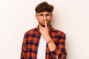 Genç İspanyol bir adam beyaz arka planda izole edilmiş düşünüyor, bakıyor, yansıtıyor, düşünüyor, bir fantezi kuruyor..