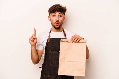 Beyaz arka planda izole edilmiş bir çanta taşıyan genç İspanyol tezgahtarın harika bir fikri var, yaratıcılık kavramı..