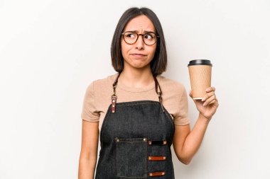 Beyaz arka planda izole edilmiş kahve içen Kafkasyalı genç garson kadın şaşkın ve kararsız hissediyor..