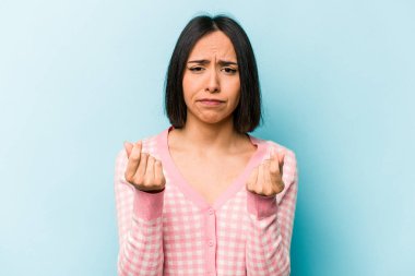 Mavi arka planda izole edilmiş genç İspanyol kadın parasız olduğunu gösteriyor..