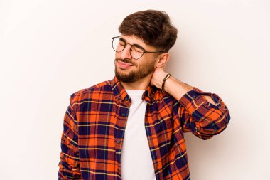 Beyaz arka planda izole edilmiş genç İspanyol bir adam stresten dolayı boynu ağrıyor, masaj yapıyor ve elle dokunuyor..