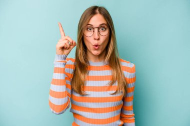 Mavi arka planda izole edilmiş beyaz bir kadın ağzı açık bir şekilde üst tarafı işaret ediyor..