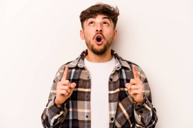 Beyaz arka planda izole edilmiş genç bir İspanyol ağzı açık bir şekilde yukarı işaret ediyor..
