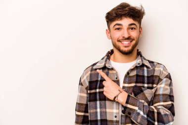 Beyaz arka planda izole edilmiş genç İspanyol adam gülümsüyor ve boş alanda bir şeyler gösteriyor..