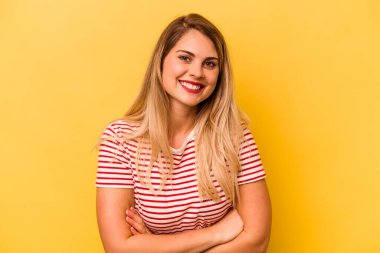 Sarı arka planda yalnız yaşayan beyaz bir kadın gülüyor ve eğleniyor..