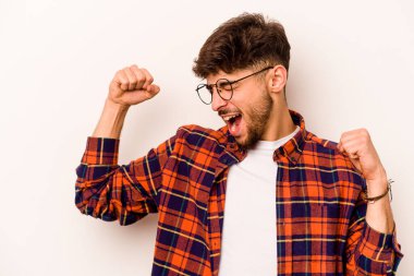 Beyaz arka planda izole edilmiş genç İspanyol bir adam zaferden sonra yumruk kaldırıyor, kazanan konsept..