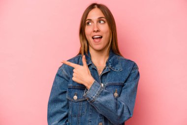 Pembe arka planda soyutlanmış beyaz bir kadın. Gülümsüyor, neşeli ve keyifli görünüyor..