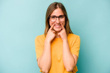 Kafkasyalı genç bir kadın mavi arka planda izole edilmiş. İki seçenek arasında şüpheli..