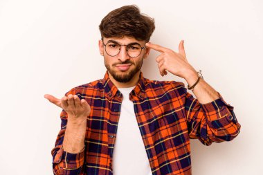 Latin kökenli genç bir adam beyaz arka planda izole edilmiş ve elinde bir ürün tutuyor..