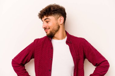 Beyaz arka planda izole edilmiş genç İspanyol adam hedeflere ve amaçlara ulaşma hayali kuruyor.