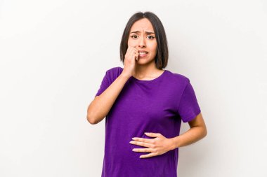 Genç Latin kökenli hamile kadın beyaz arka planda izole edilmiş tırnak yiyor, gergin ve çok endişeli..