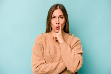 Kafkasyalı genç bir kadın mavi arka planda izole edilmiş. Harika bir fikri var, yaratıcılık kavramı..