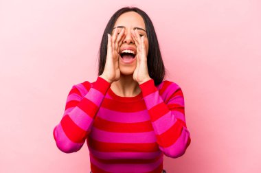 Pembe arka planda izole edilmiş genç İspanyol kadın heyecanla bağırıyor..