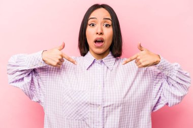 Pembe arka planda izole edilmiş genç İspanyol kadın parmaklarıyla aşağıya doğru, pozitif duygu..