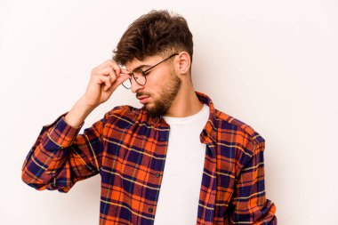 Beyaz arka planda izole edilmiş genç İspanyol bir adamın başı ağrıyor, yüzüne dokunuyor..
