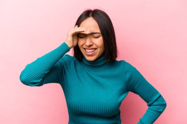 Genç İspanyol kadın pembe arka planda izole edilmiş neşeli bir şekilde gülüyor. Mutluluk kavramı.