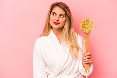 Kafkasyalı genç bir kadın arka planda pembe bir kazı kazanı tutuyor. Amaçlarına ve amaçlarına ulaşma hayalleri kuruyor.