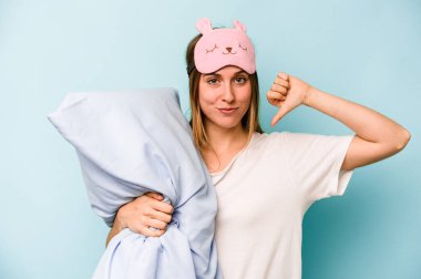 Mavi arka planda izole edilmiş pijama giyen genç beyaz kadın gururlu ve kendinden emin hissediyor, örnek olarak.