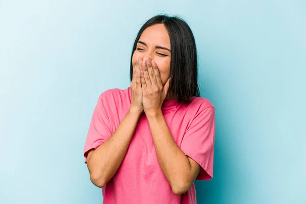 Νεαρή Ισπανίδα Απομονωμένη Μπλε Φόντο Γελώντας Για Κάτι Καλύπτοντας Στόμα — Φωτογραφία Αρχείου