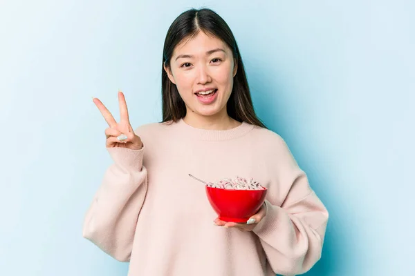 Jonge Aziatische Vrouw Met Een Kom Van Granen Geïsoleerd Blauwe — Stockfoto
