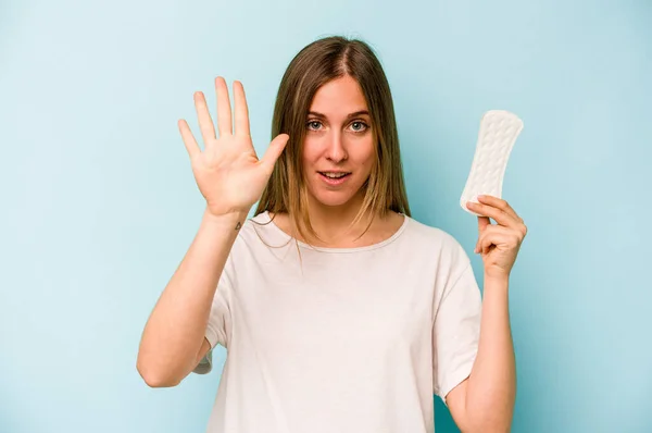 Junge Kaukasische Frau Hält Sanitärserviette Isoliert Auf Blauem Hintergrund Und — Stockfoto