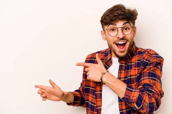 Beyaz arka planda izole edilmiş genç bir İspanyol işaret parmaklarıyla işaret ederek heyecanlanıyor..